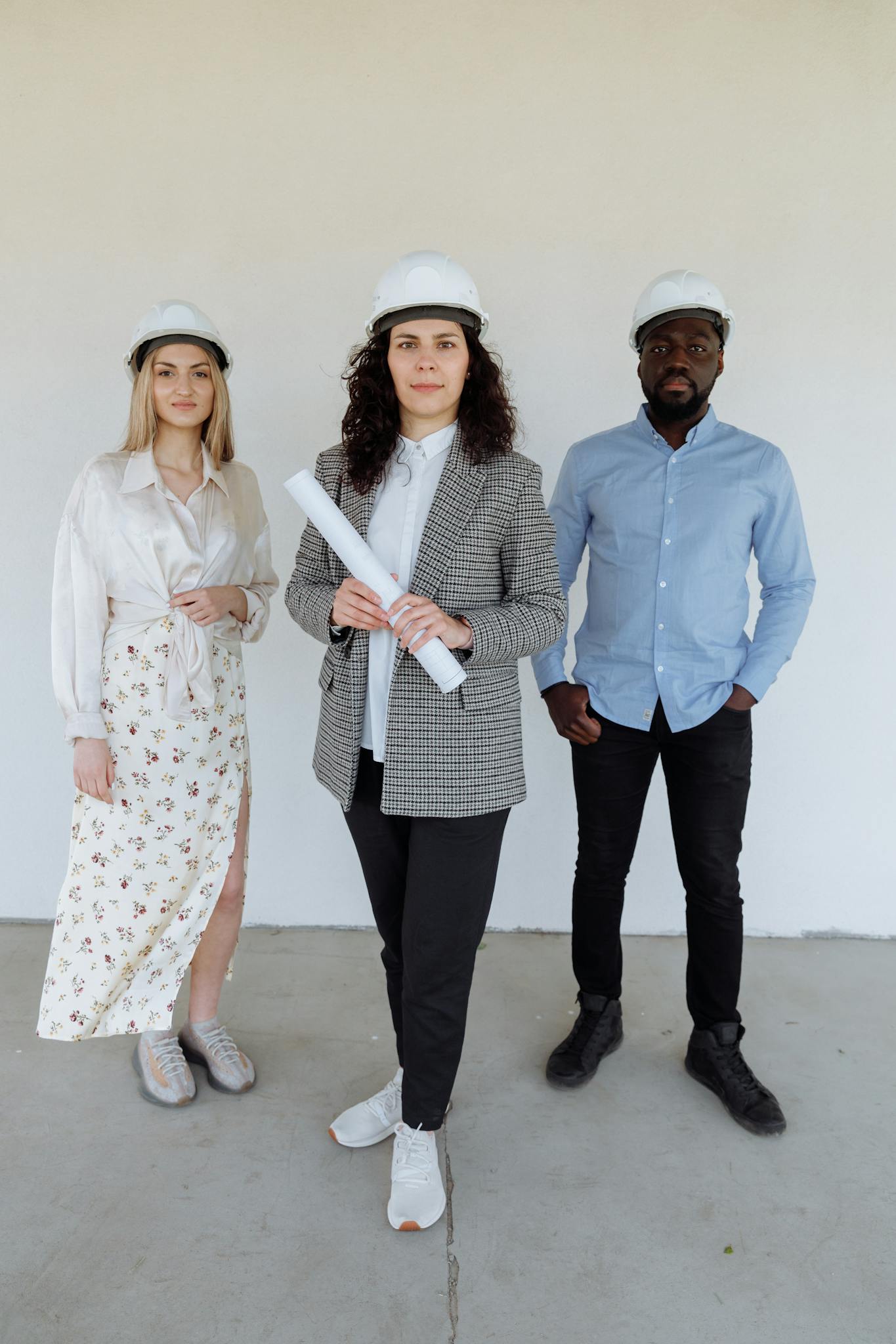 Diverse group of architects in white helmets discussing a construction project indoors.